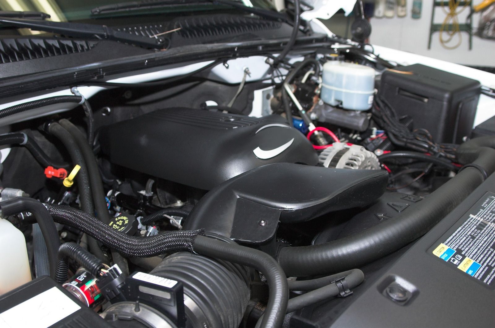 A close up of a car engine with the hood open