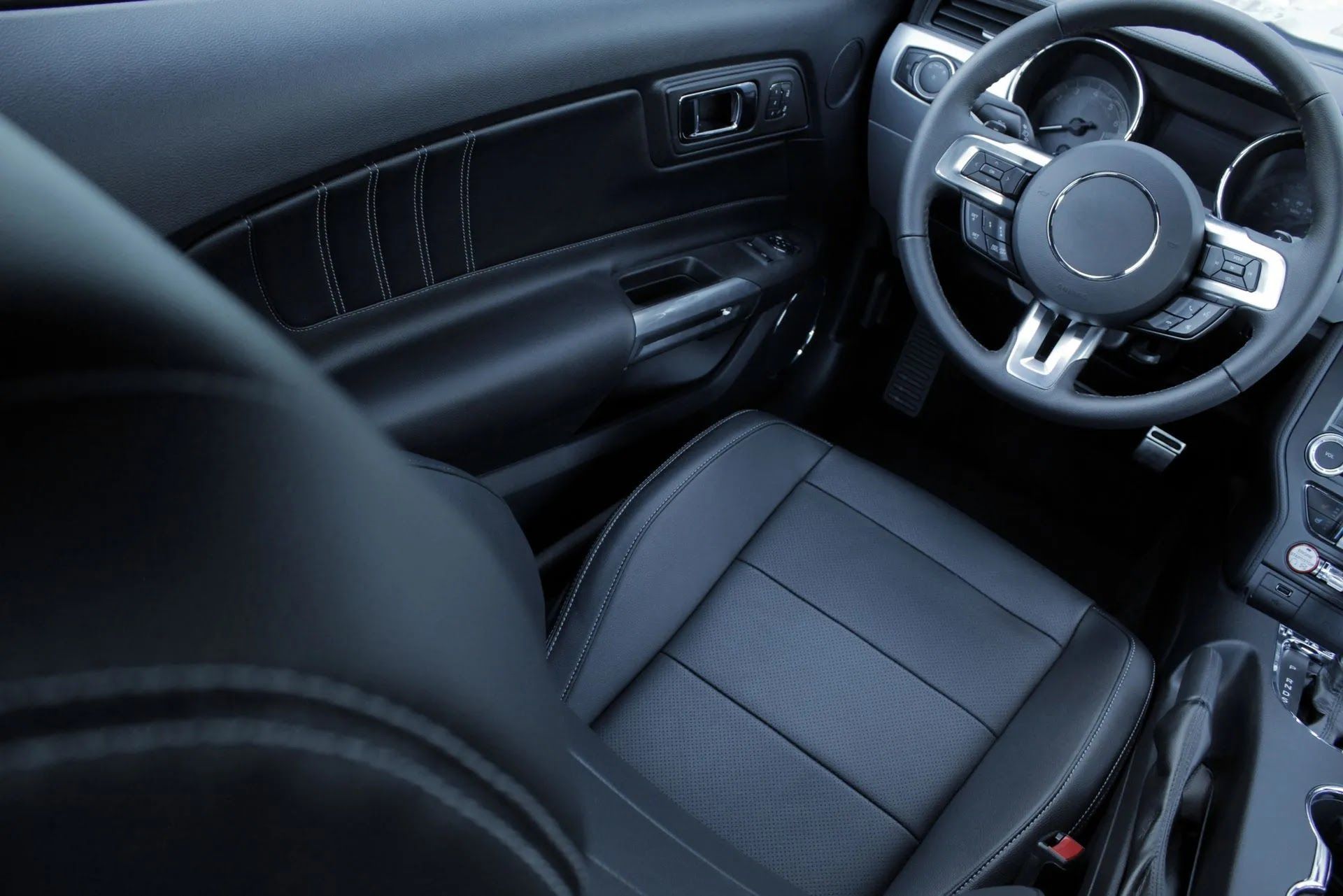 The interior of a car with black leather seats and a steering wheel