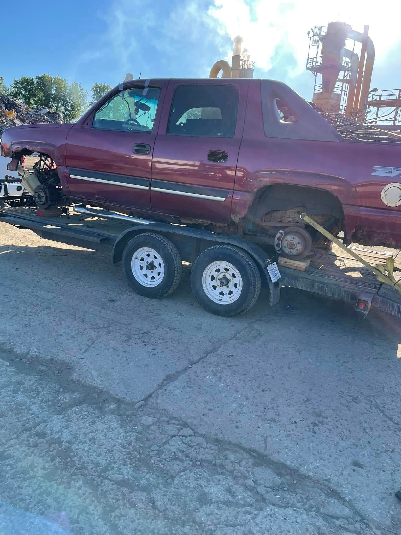 A red truck is sitting on top of a trailer.