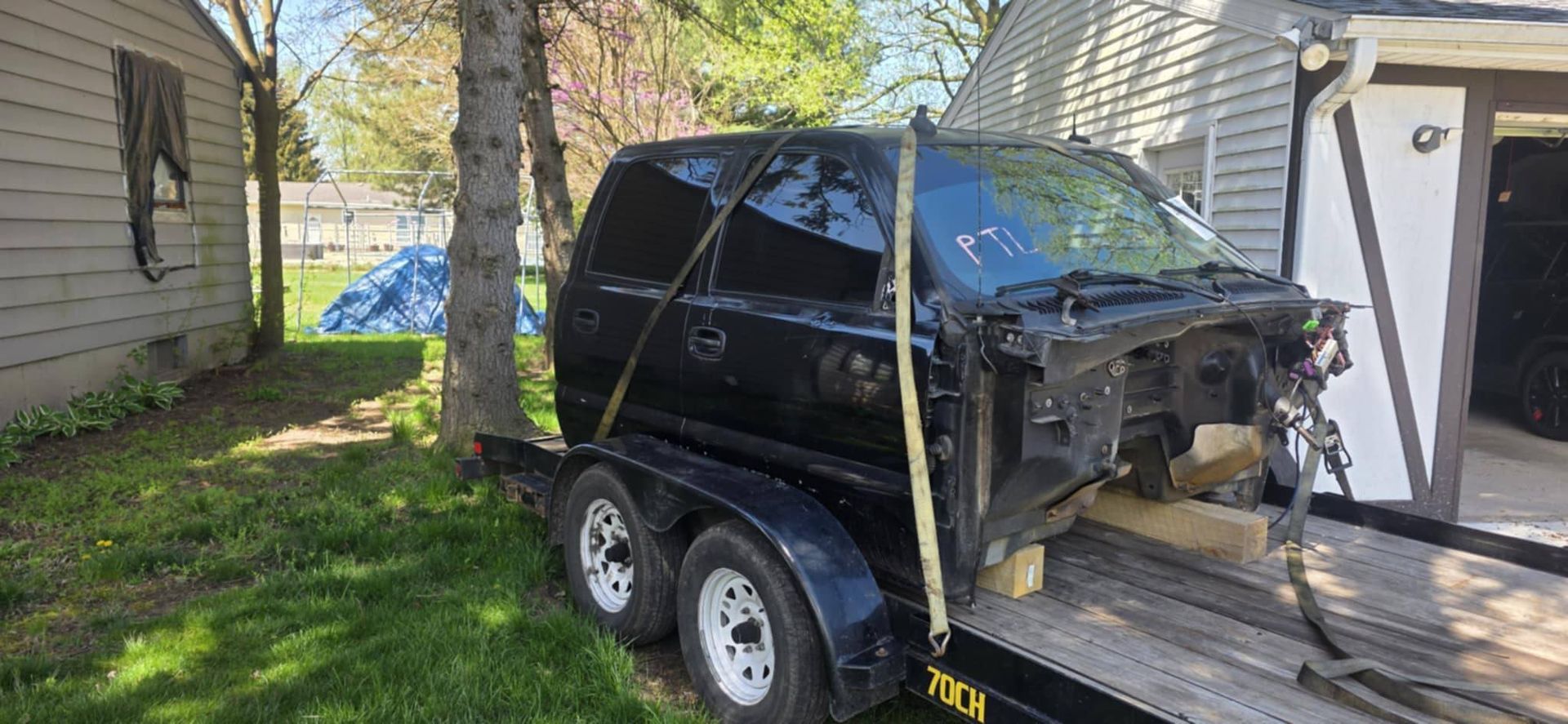 A black van is being towed on a trailer.