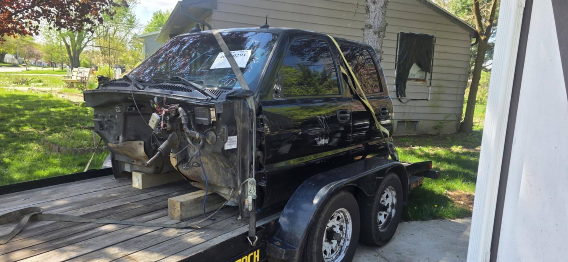A black truck is sitting on top of a trailer.