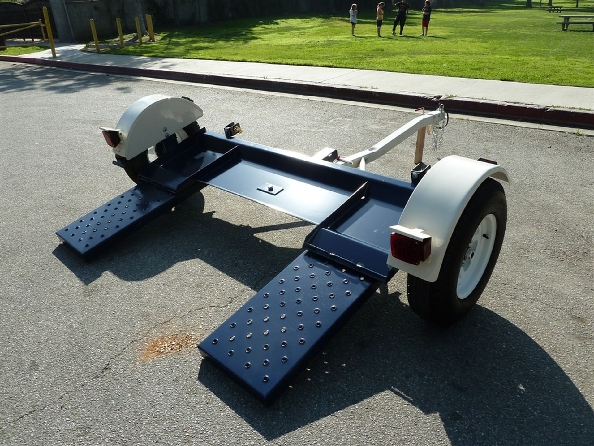 A blue and white trailer is parked on the side of the road