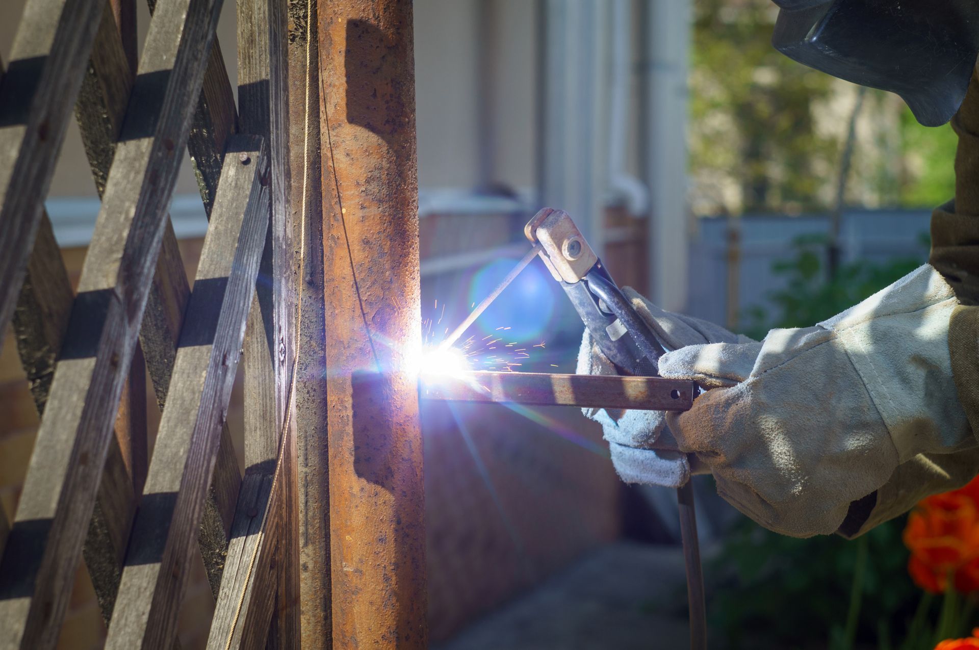Close-up of welding metal with bright sparks during outdoor fabrication work.