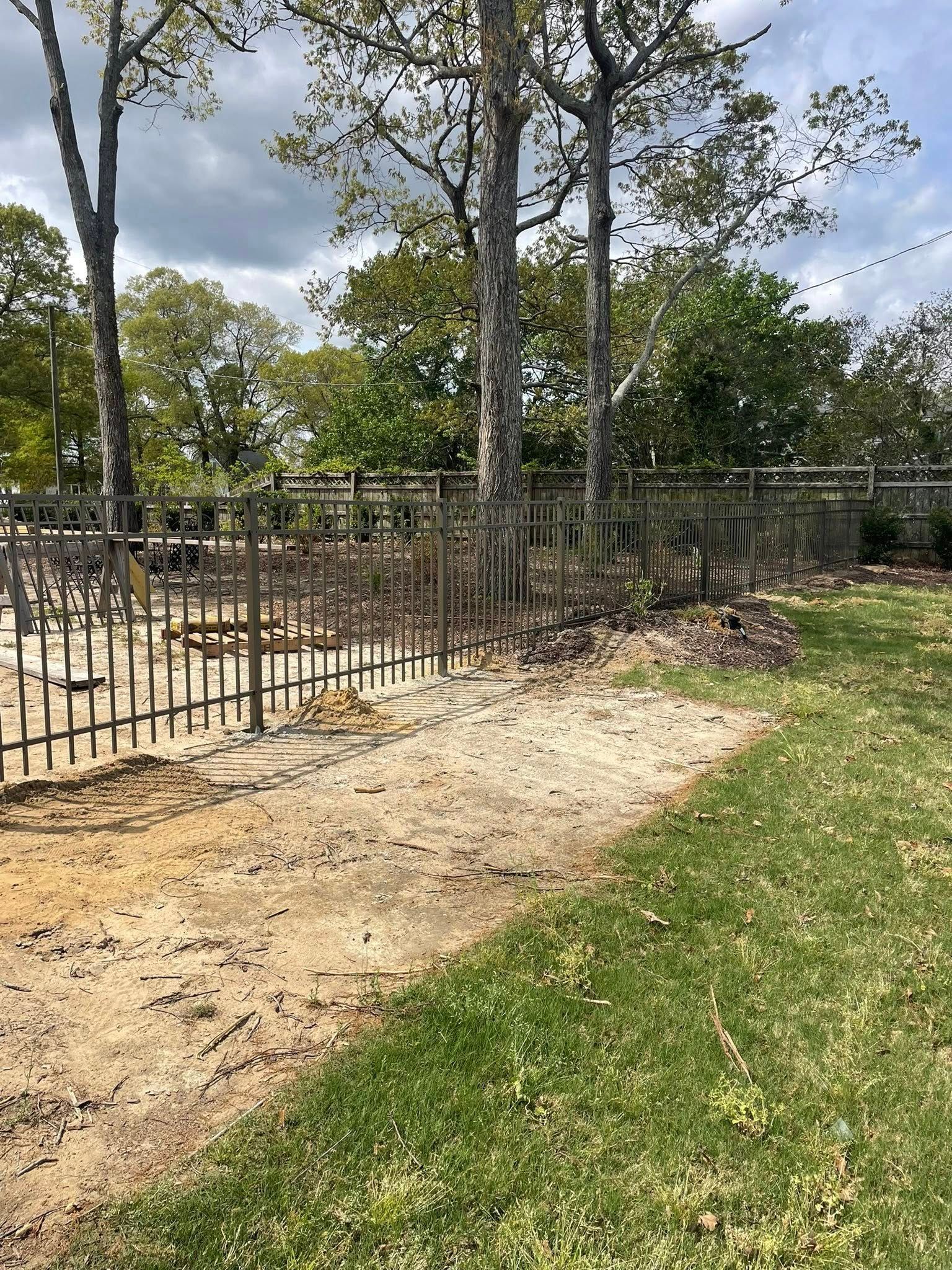 White picket fence enclosure with blue trash bin on concrete. White picket fence enclosure with blue trash bin on concrete.