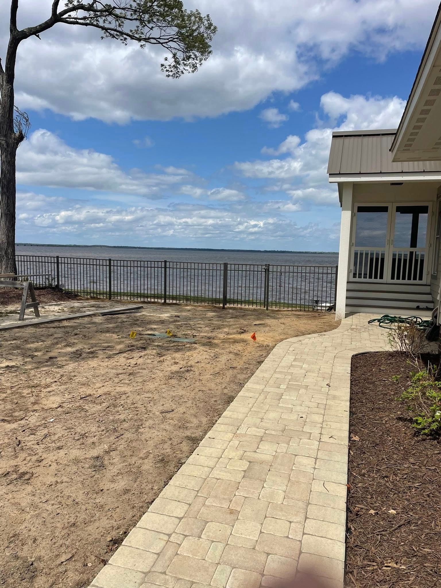 Brown wooden fence in a yard next to a building on a sunny day. Brown wooden fence in a yard next to a building on a sunny day.