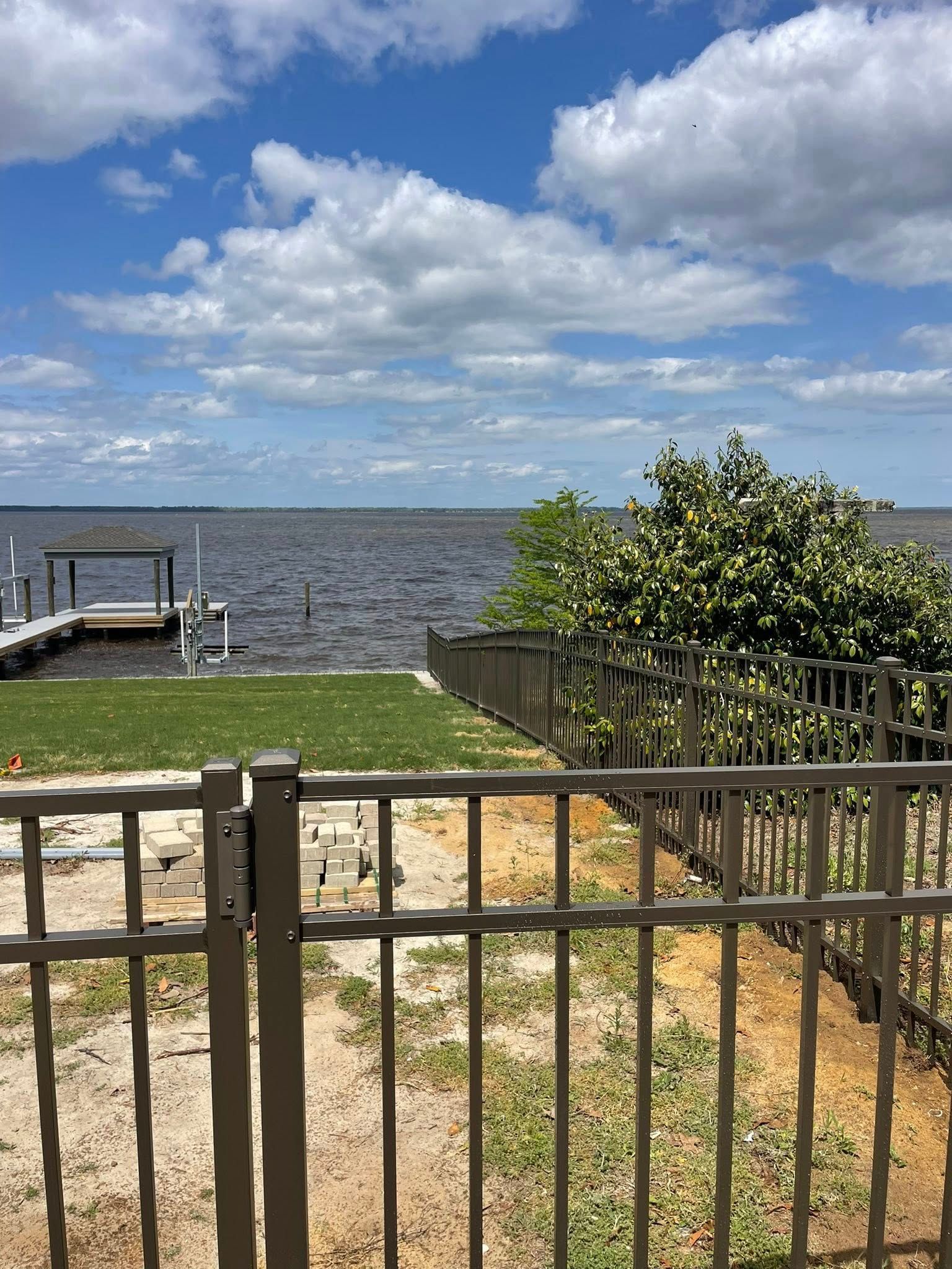 Wooden fence with three sections, stained light brown, next to a building. Wooden fence with three sections, stained light brown, next to a building.
