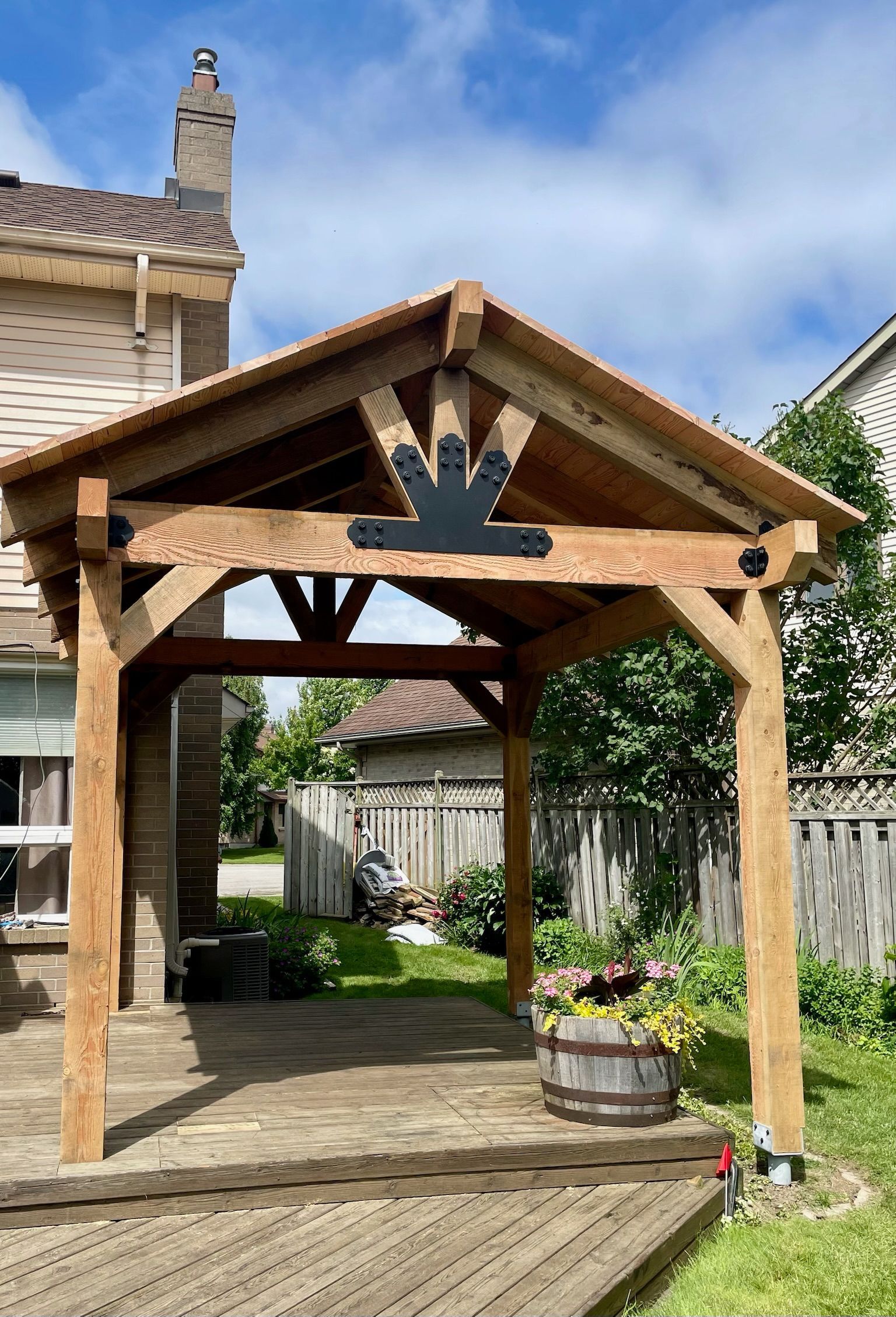 A wooden gazebo is in the backyard of a house built by Ironside Construction