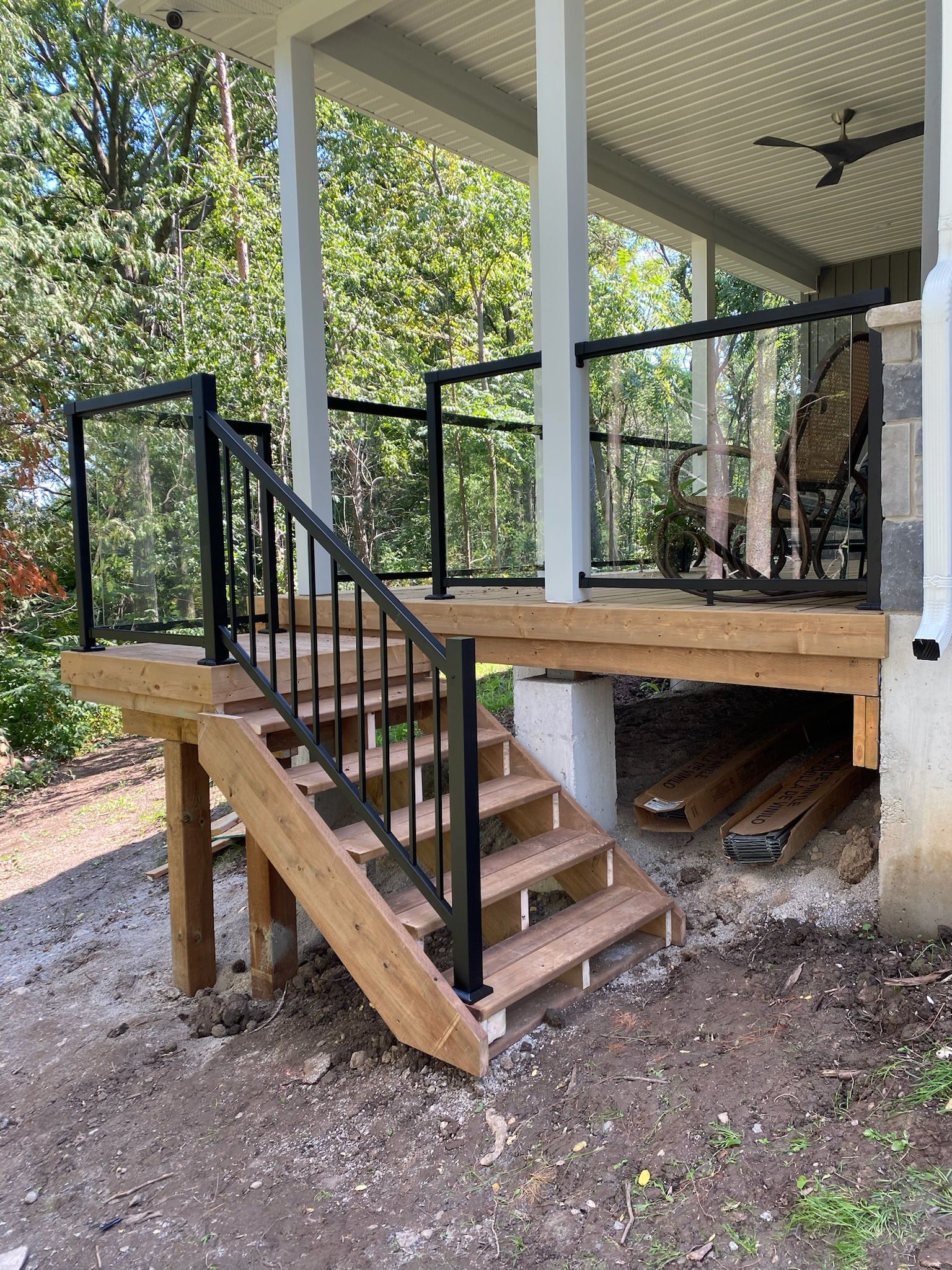 A wooden deck with stairs leading up to a porch built by Ironside Construction