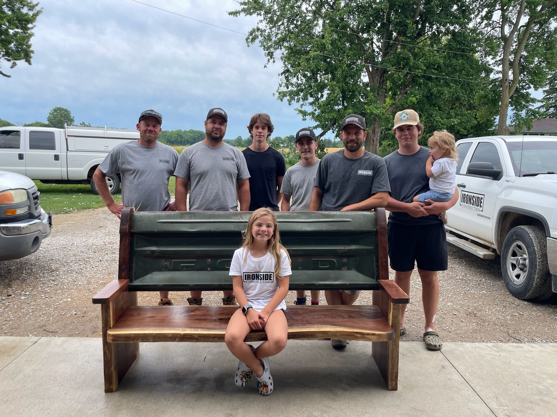 Ironside Construction family standing around a wooden bench.
