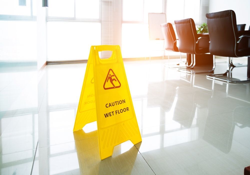 A Yellow Caution Sign is Sitting on the Floor in an Office — Dawsons Cleaning Specialist In Mount Louisa, QLD