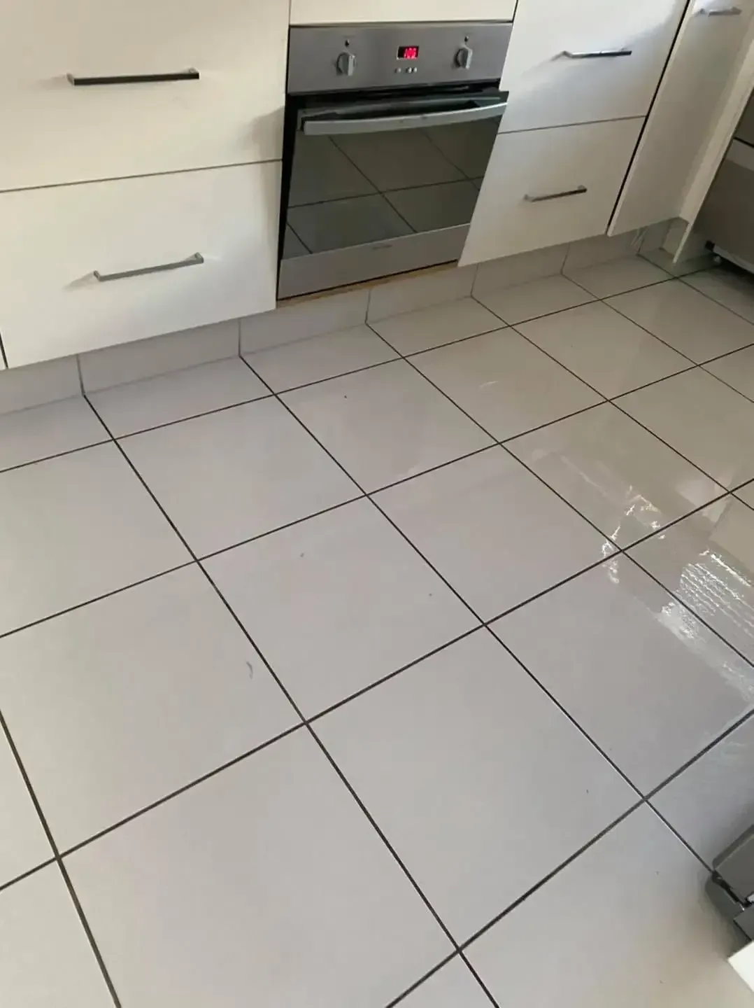 A Kitchen With White Tile Floors and White Cabinets — Dawsons Cleaning Specialist In Mount Louisa, QLD