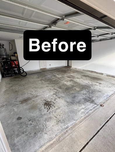 A gray, stained concrete garage floor viewed from the entrance, labeled with a black