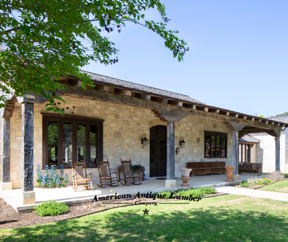 Front porch of stone home with rocking chairs and decorative reclaimed hand hewn posts and beams in Frio, Texas.