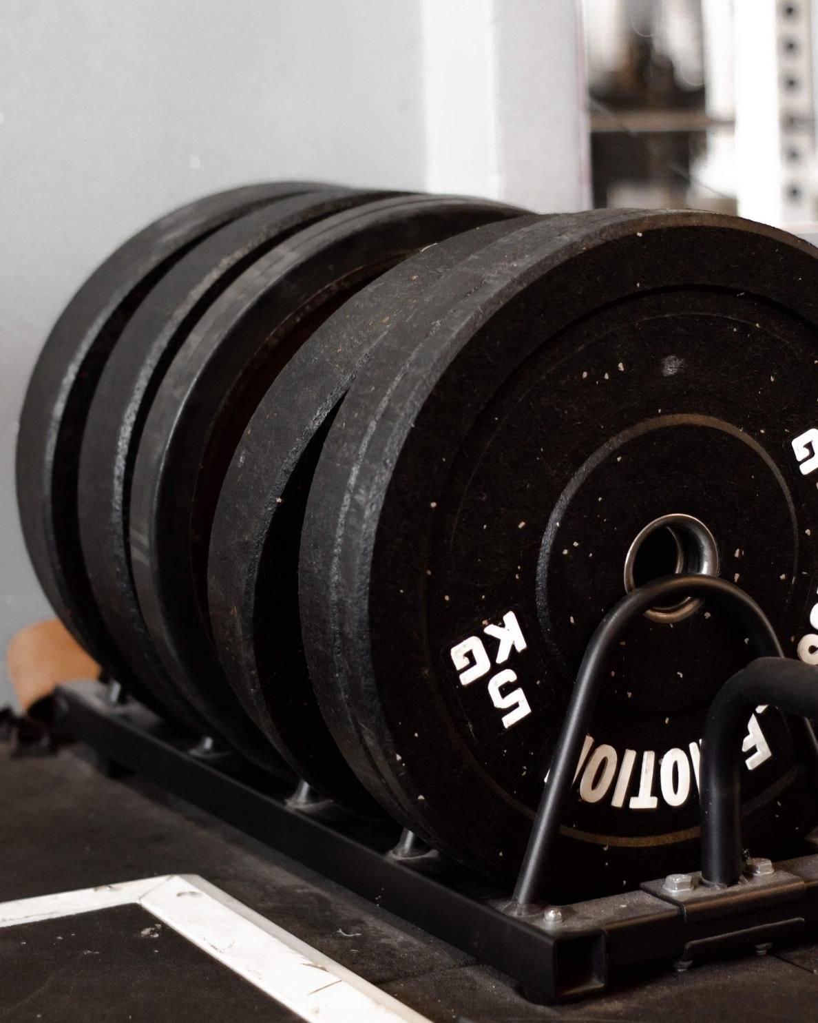 A Stack of Weight Plates In A Gym — The Factory Gym in Taree, NSW