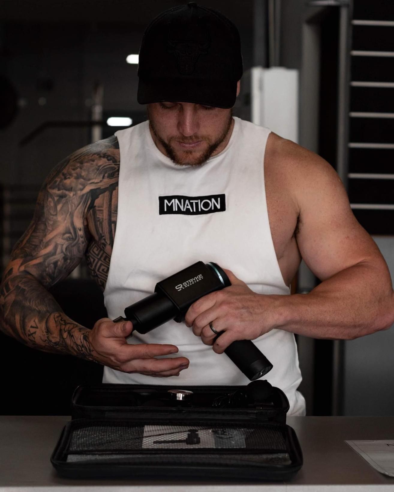 A Man is Holding an Electric Massager — The Factory Gym in Taree, NSW