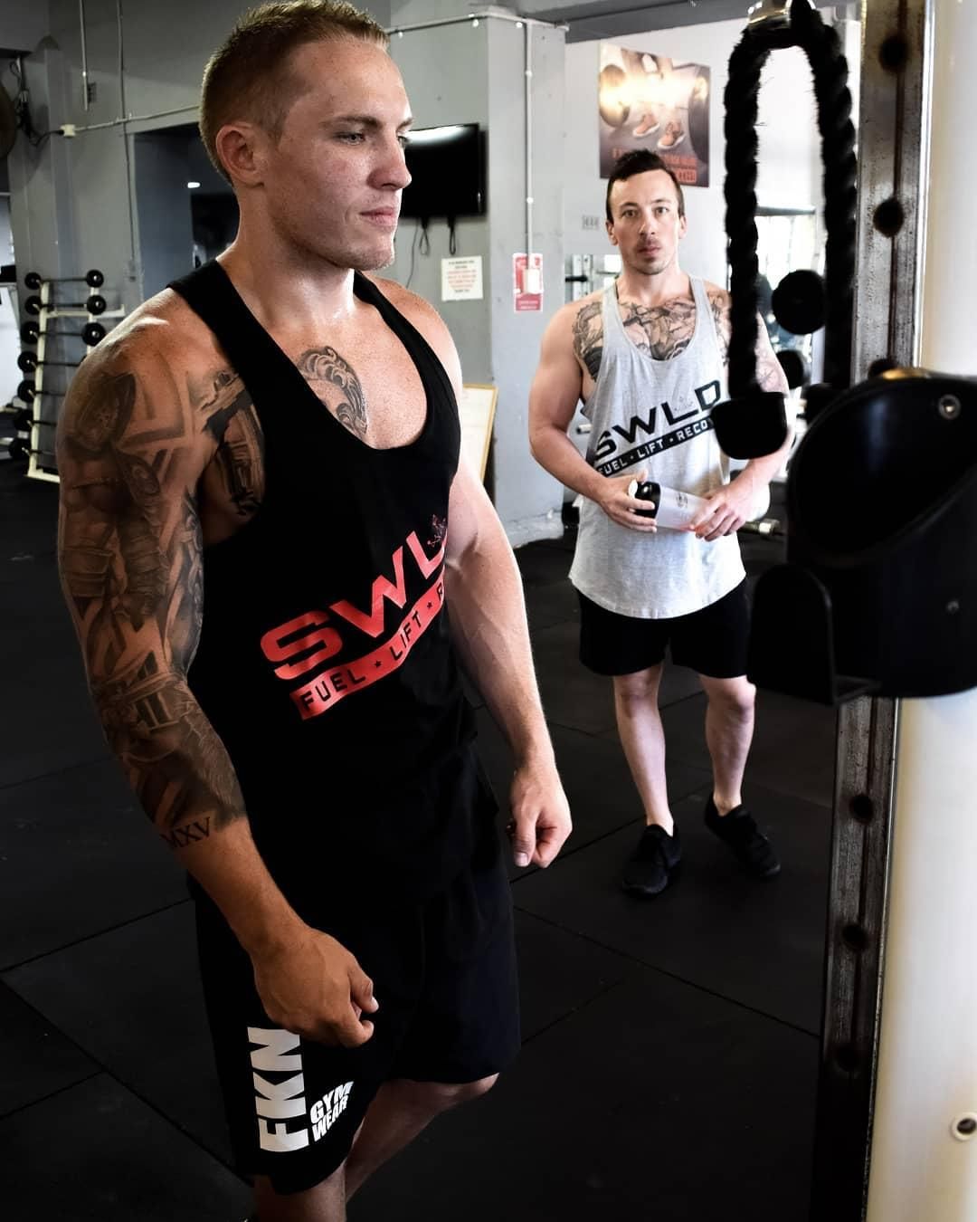 A Man Wearing a Tank Top That Says SWL is Standing in a Gym — The Factory Gym in Taree, NSW
