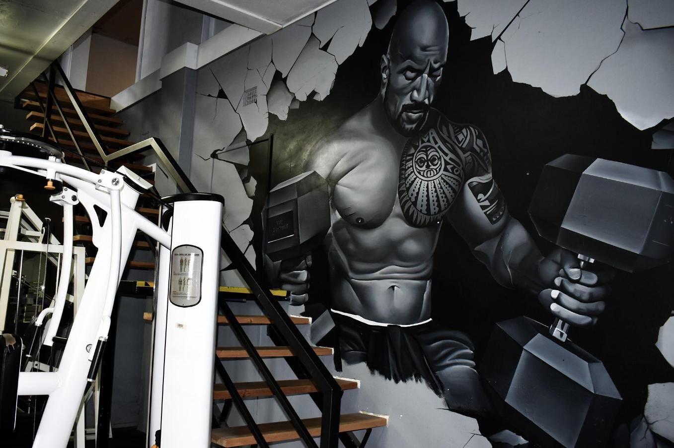 A Mural of a Muscular Man Holding a Dumbbell in a Gym — The Factory Gym in Taree, NSW