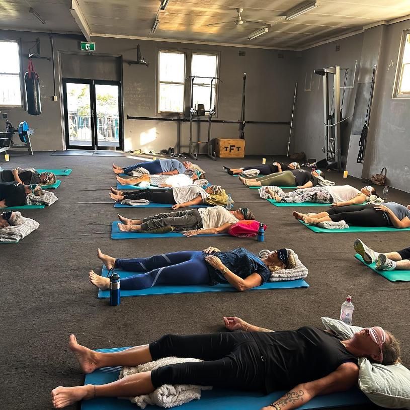A Group of People Are Laying on Yoga Mats in a Gym — The Factory Gym in Taree, NSW