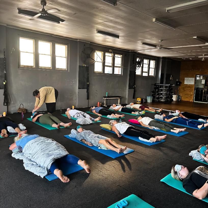 A Group of People Are Laying on Yoga Mats in a Gym — The Factory Gym in Taree, NSW