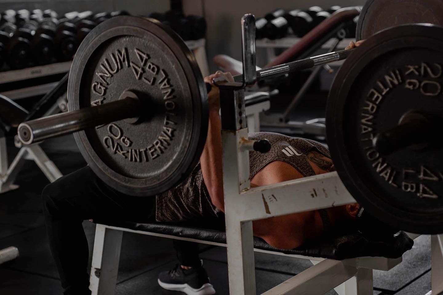 A Woman is Lifting a Barbell on a Bench in a Gym — The Factory Gym in Taree, NSW