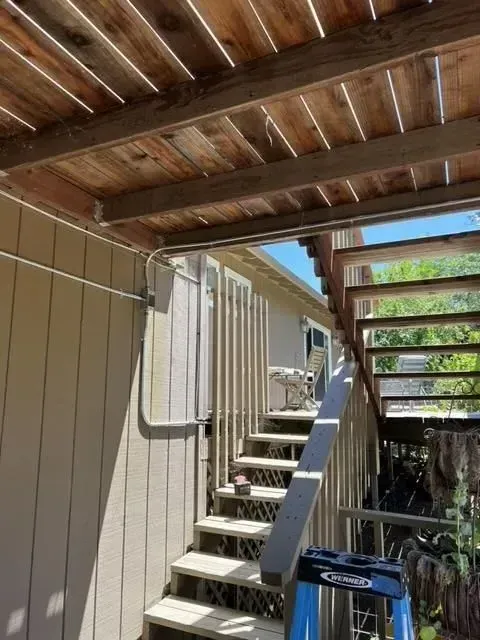 A ladder is sitting on the side of a wooden staircase.