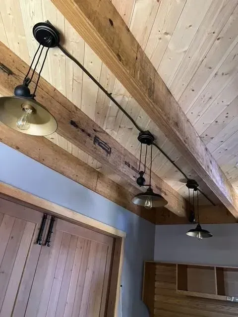 A wooden ceiling with a row of lights hanging from it.
