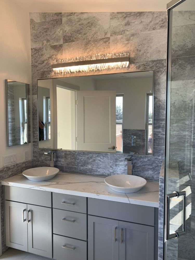 A bathroom with two sinks and a large mirror.