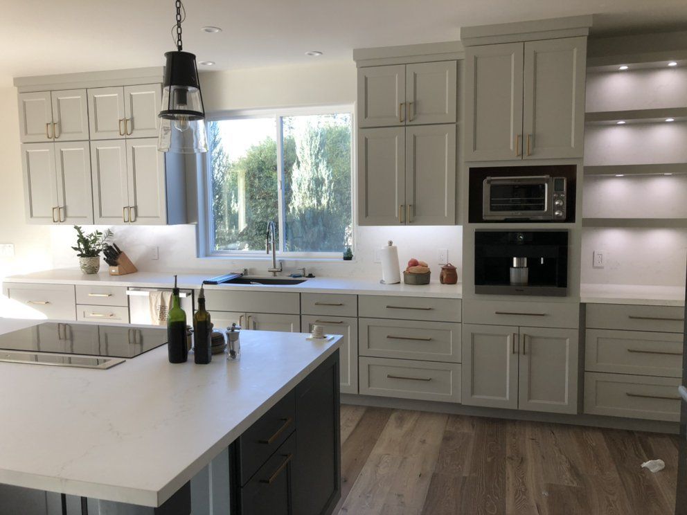 A kitchen with white cabinets and a large island