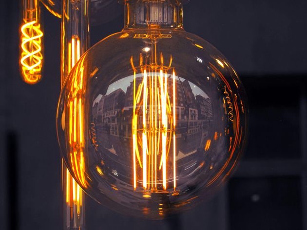 A close up of a light bulb hanging from a ceiling.