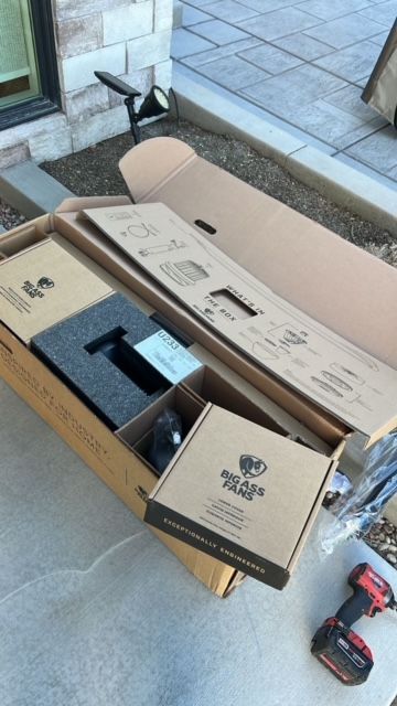 A cardboard box with a black and decker drill next to it