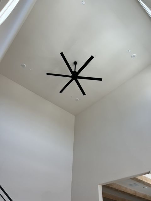 A ceiling fan in the shape of a star is hanging from the ceiling
