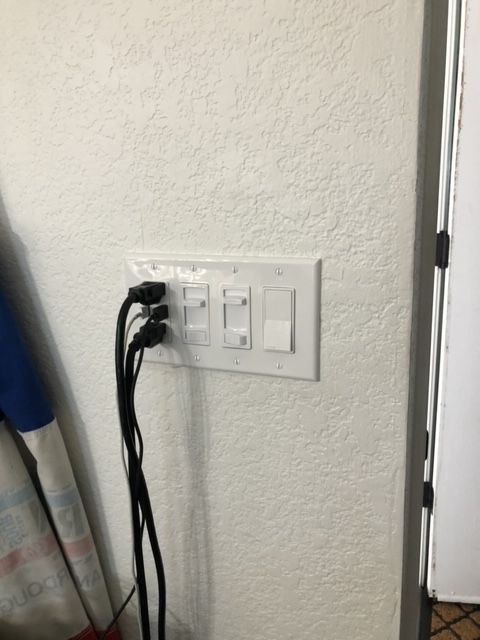 A white wall with a bunch of wires plugged into it