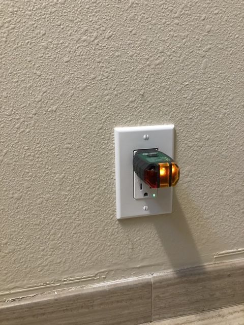 A plug is plugged into an outlet on a wall.