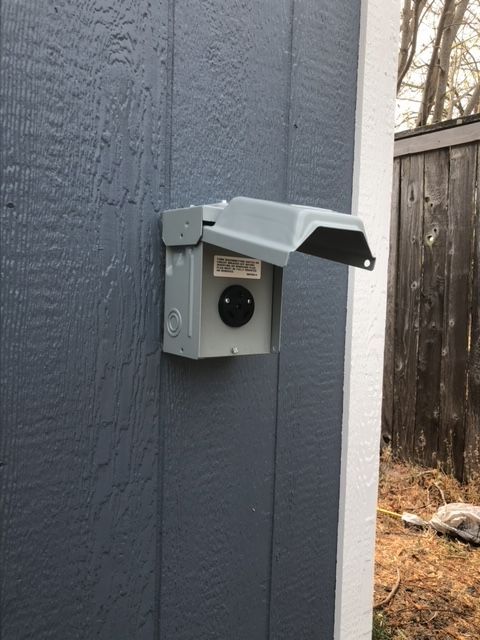 There is a box on the side of a building with a cover on it.