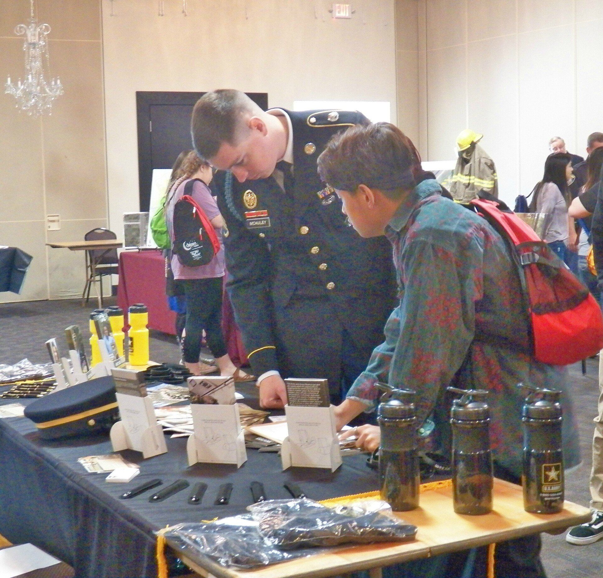 A man in a military uniform talks to another man