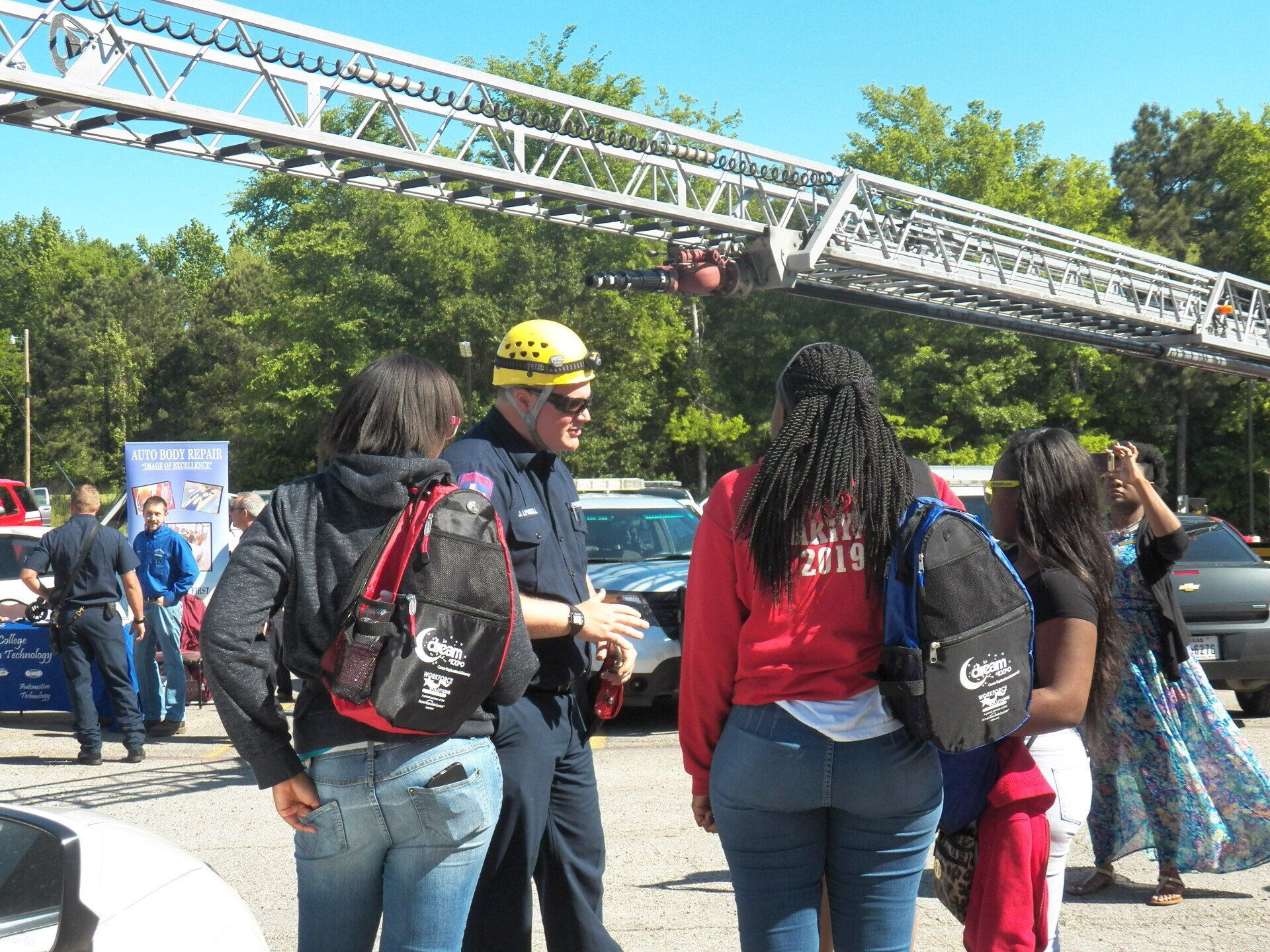 A group of people standing in front of a fire ladder