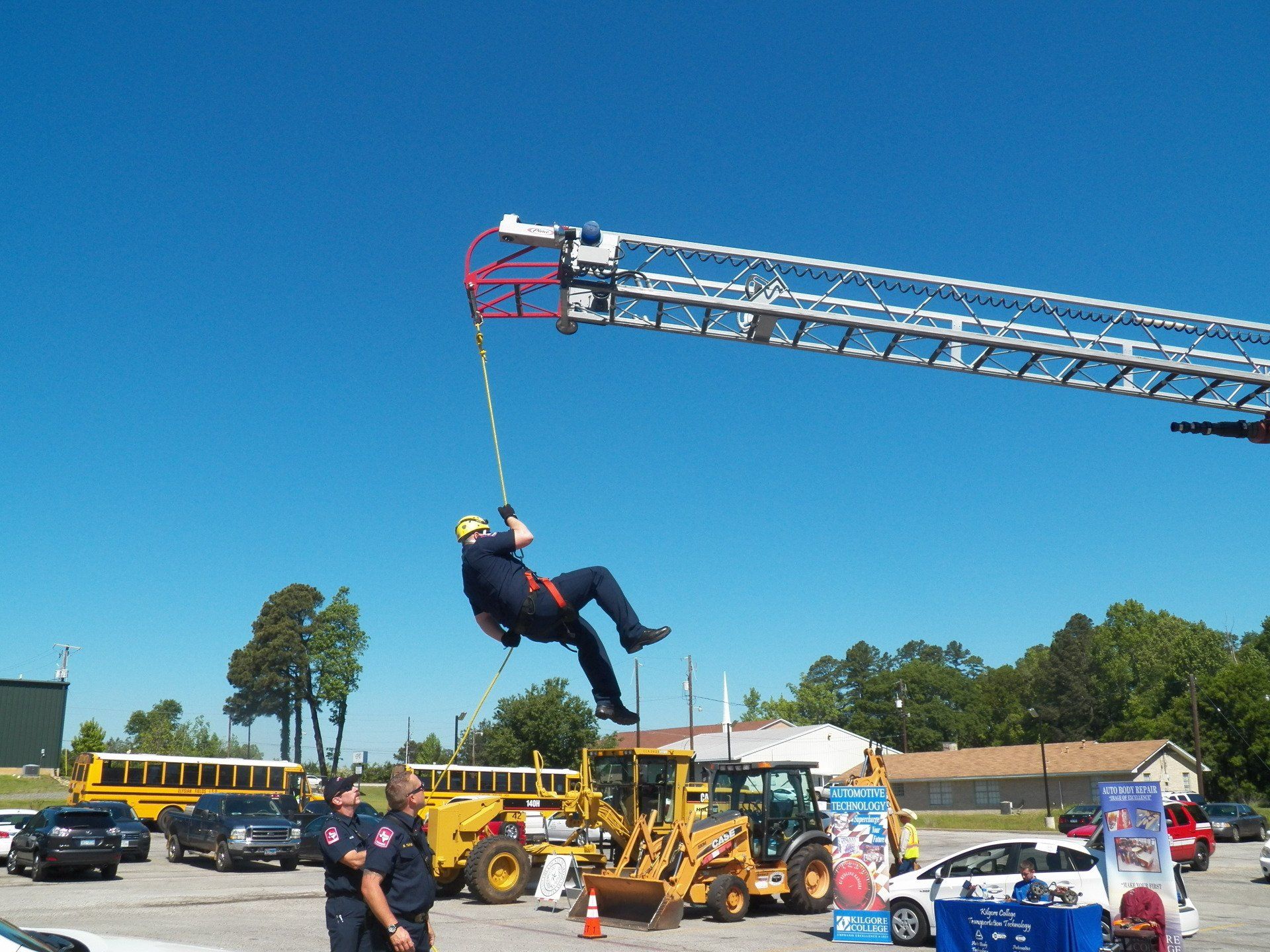A man is being rescued from a ladder in a parking lot