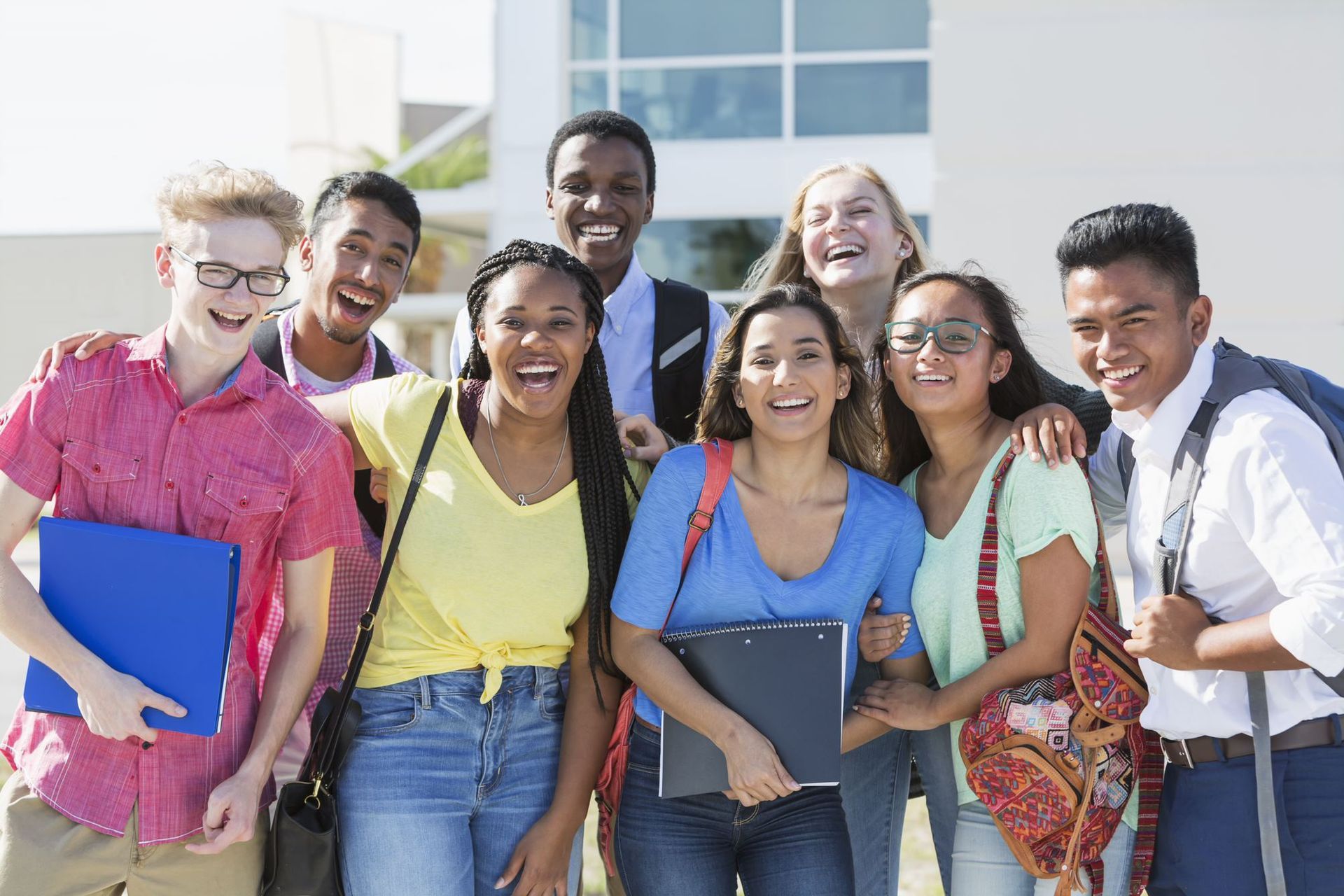A group of young people are posing for a picture in front of a building.