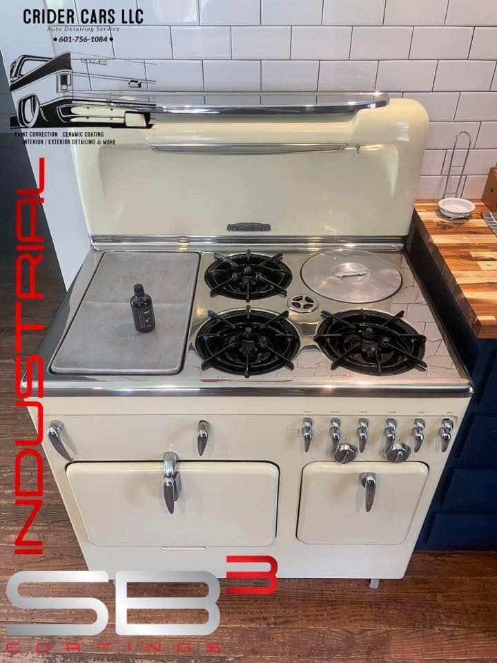 A white stove with four burners and a stove top oven in a kitchen.