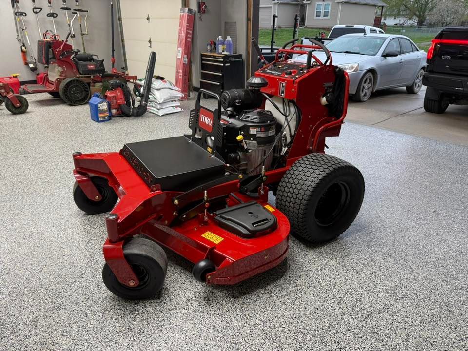 A red lawn mower is parked in a garage.