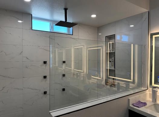 A bathroom with a walk in shower and a mirror.