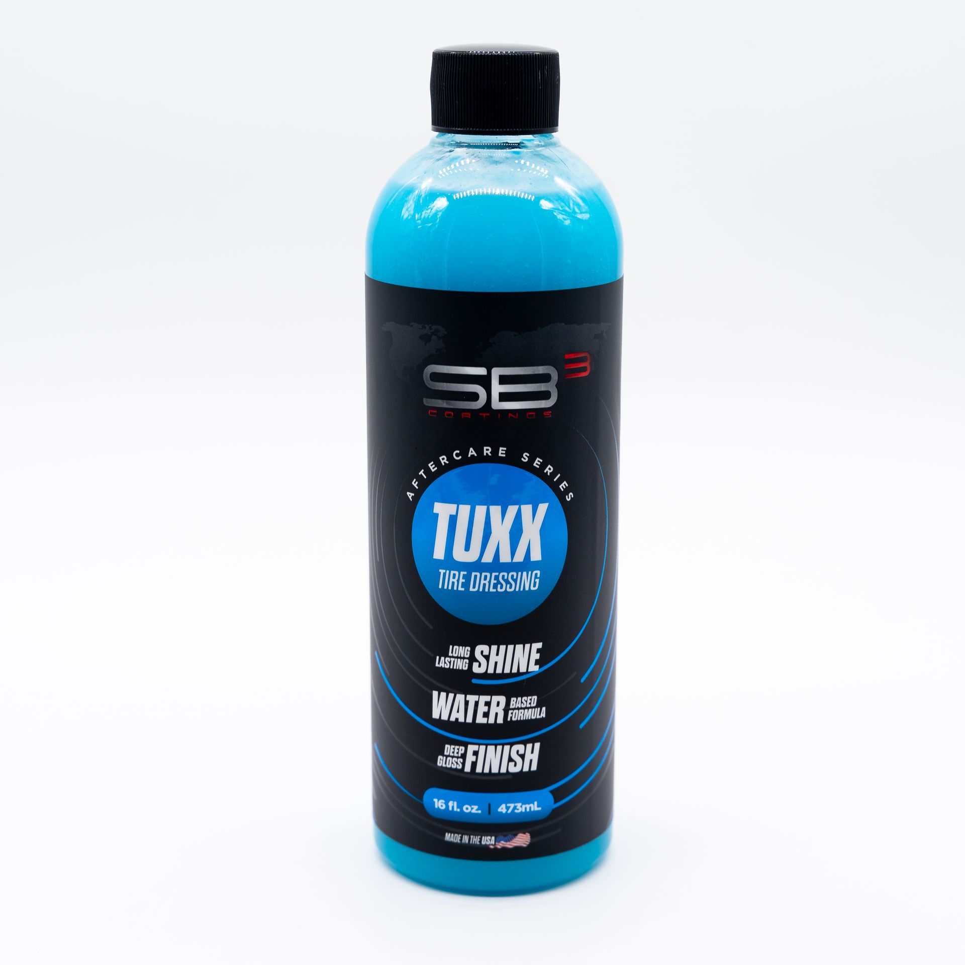 A blue bottle of tuxx sits on a white surface