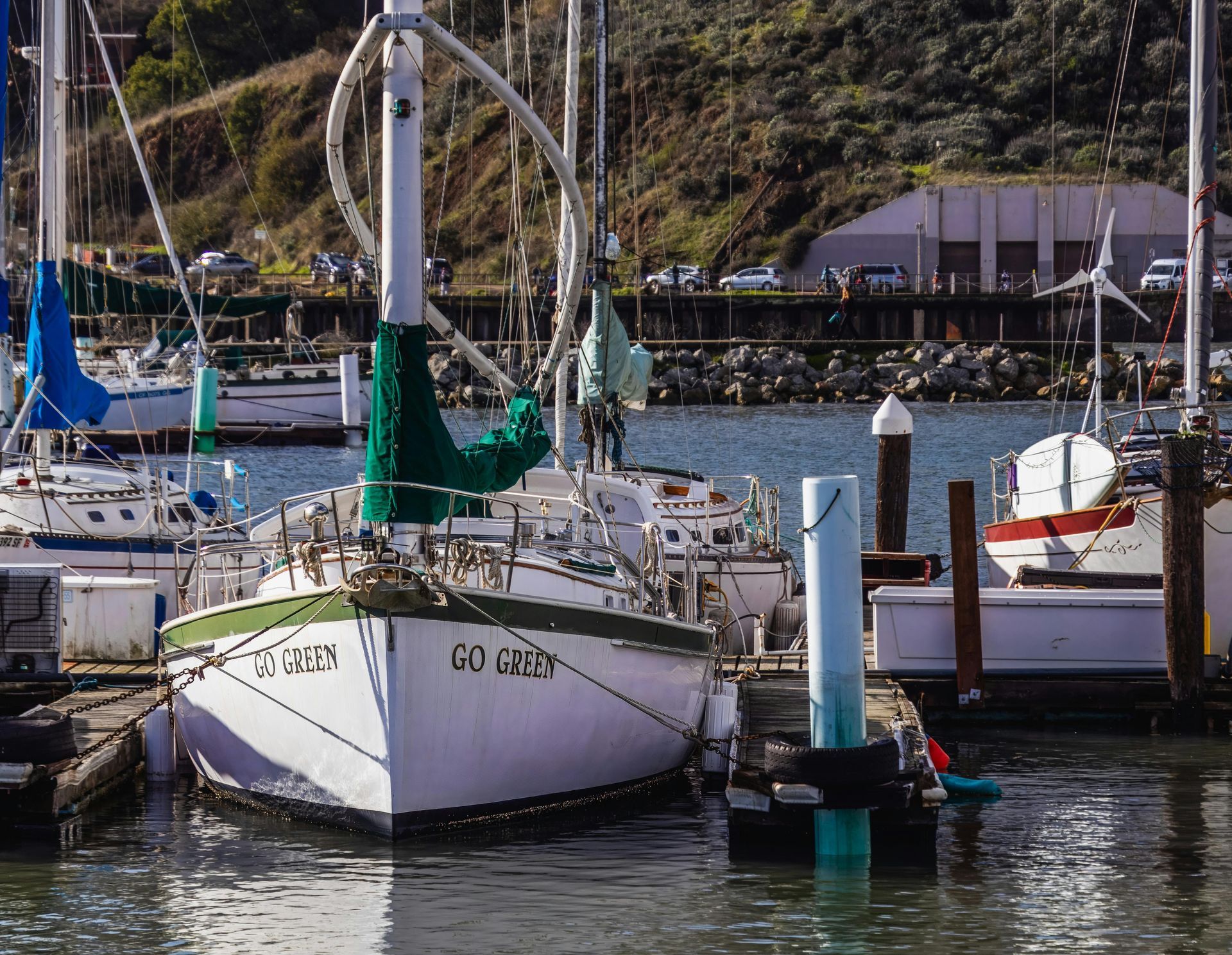 Boats are docked in a harbor and one of them has the name go daddy on it