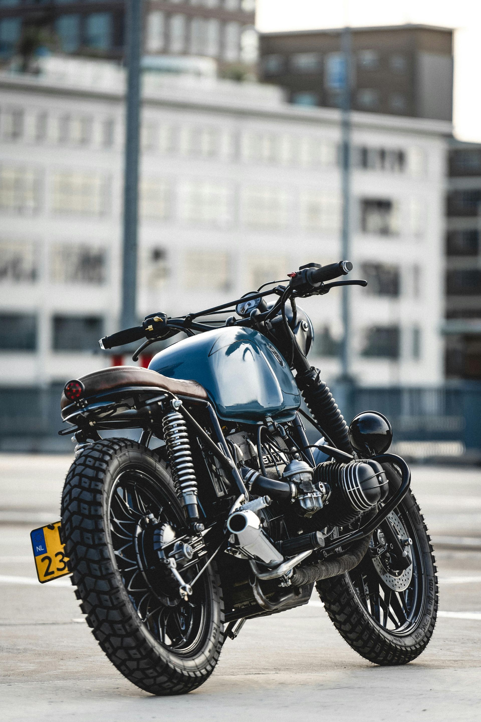 A blue motorcycle is parked in front of a building.