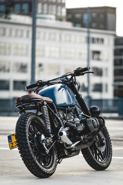 A blue motorcycle is parked in front of a building.