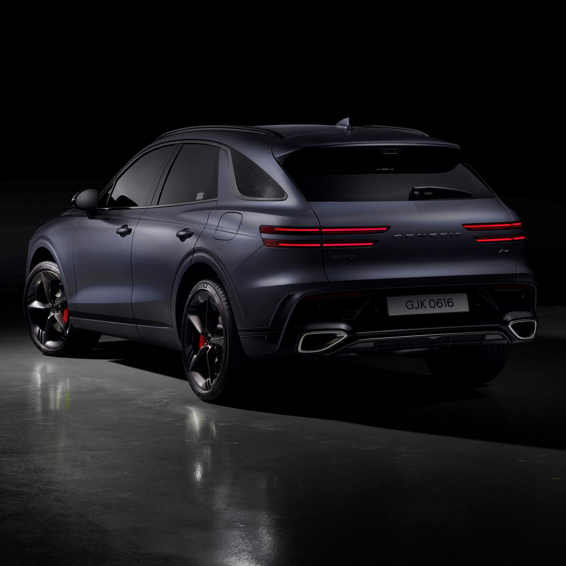 A black car is parked in a dark room.