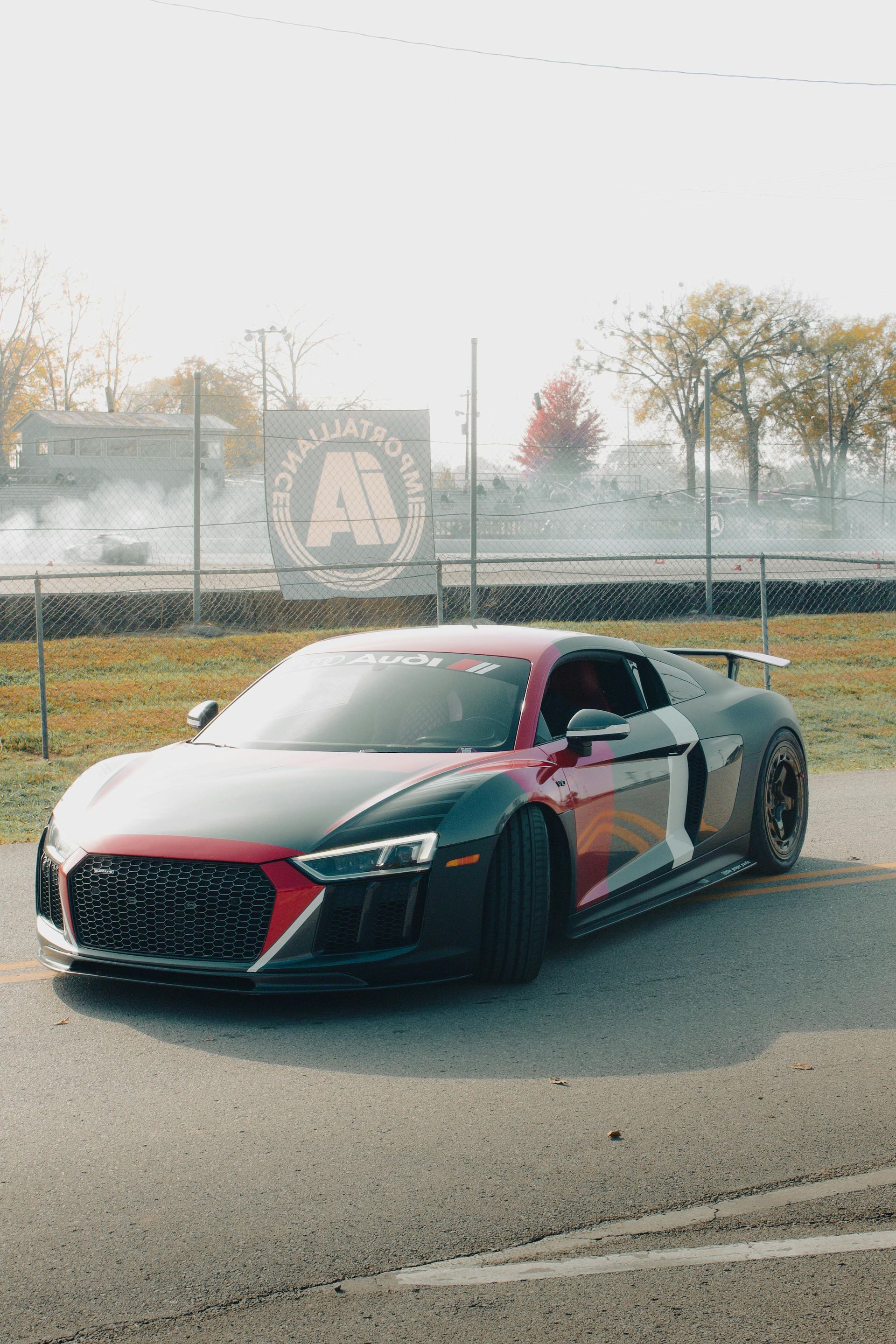 A black and red sports car is parked on the side of the road.
