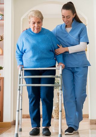Nurse Helping a Senior Woman Walking with a Mobility Walker — Mason, OH — Distinguished Orthopedic Home Care