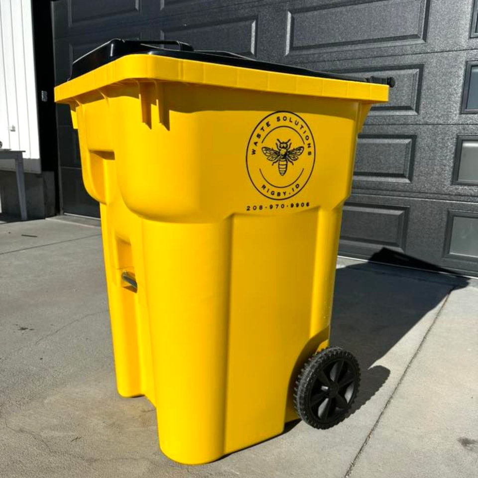 Yellow waste bin with black lid and logo. The bin has two wheels.