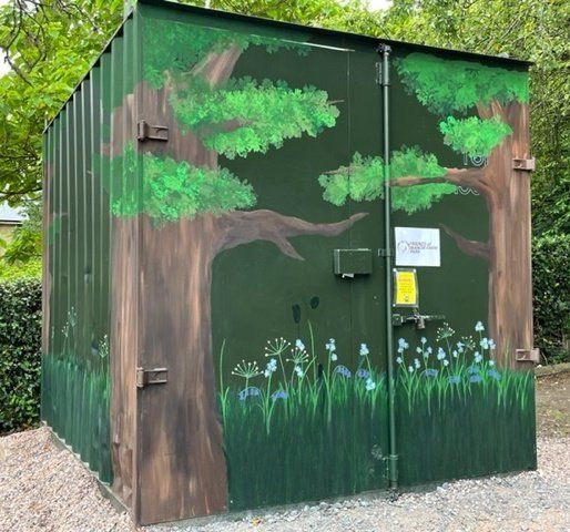 Metal container with flowers and trees painted on it.